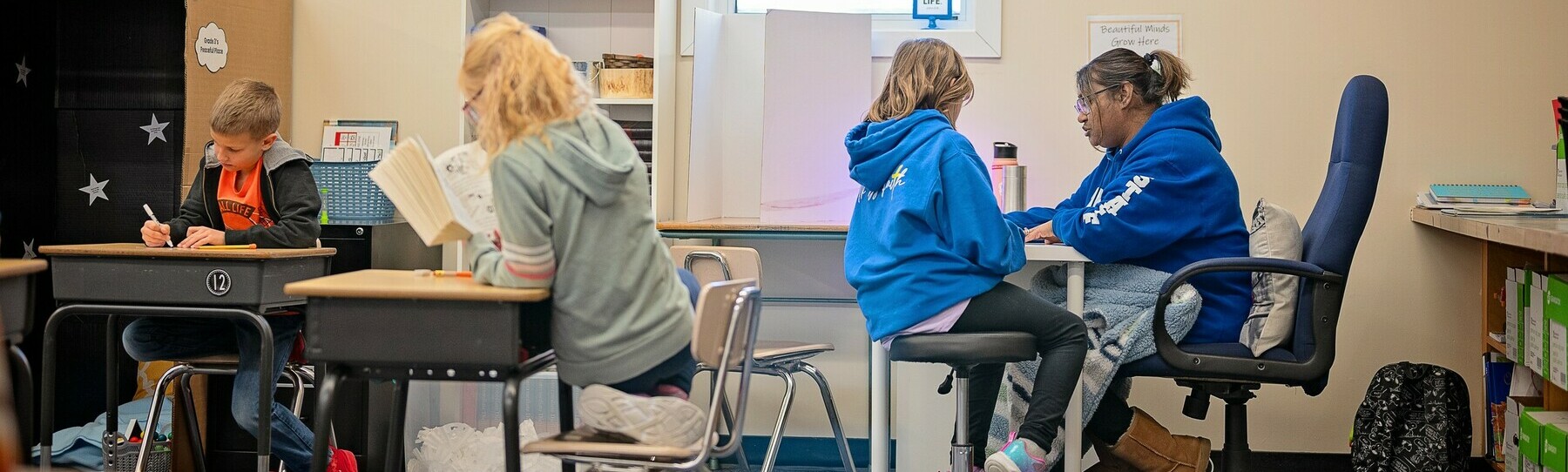 children at tables in a lower elementary classroom